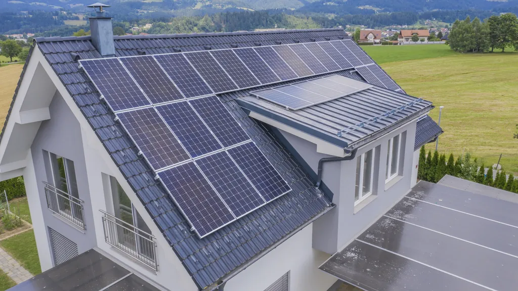 Luftaufnahme eines Einfamilienhauses mit schwarzen Solarmodulen auf dem ganzen Dach
