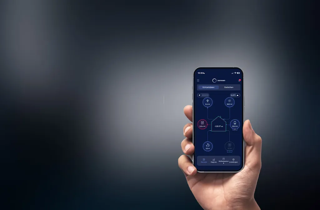 Hand mit Smartphone, auf dem die sonnen sonnenPro App die Energieflüsse eines Gebäudes zeigt